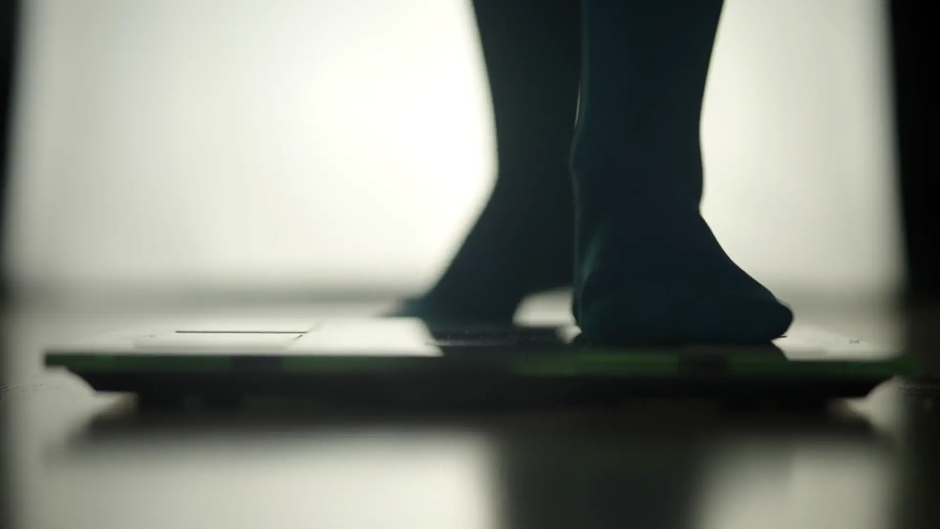 Person stepping onto a bathroom scale at home
